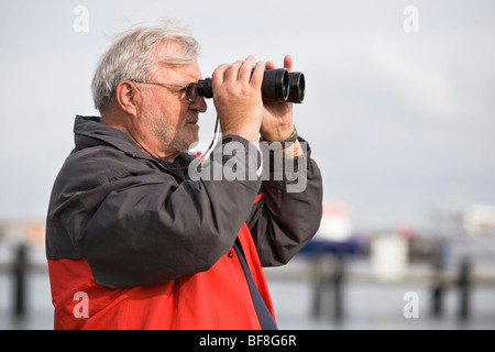 Senior man looking through binoculars Stock Photo