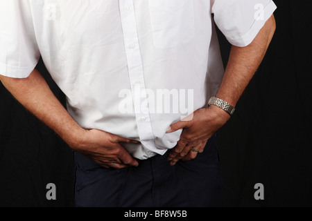 Late middle aged man suffering from severe prostate pain suffering from prostate cancer common male disease growing old aging Stock Photo