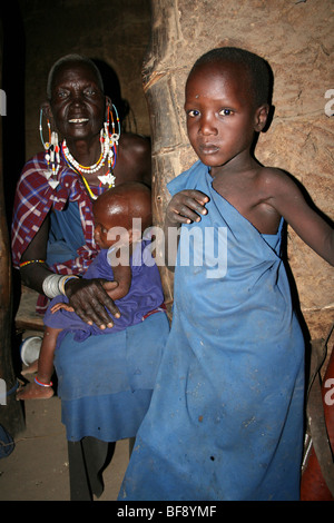 Elderly Masai Woman With Grandchildren In Her Home In Engaruka Village, Rift Valley, Tanzania Stock Photo