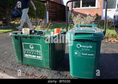 Green kerbside recycling boxes for glass and food waste waiting for collection outside a house. Surrey England UK Britain Stock Photo