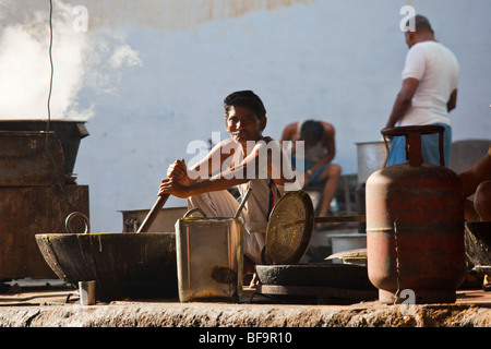 Stirring a large pan of Daal during the camel fair in Pushkar in Rajasthan India Stock Photo