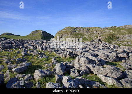 Man walking on the Limestone Pavement at Malham Yorkshire Dales Stock Photo