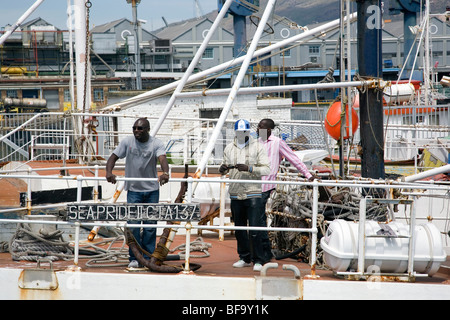 Boats at Cape Town harbour with 3 guys on board Stock Photo