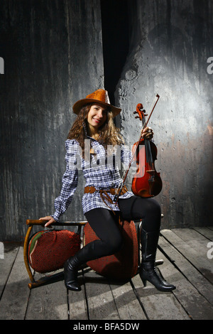 Beautiful violinist country performer on grey wall background Stock Photo