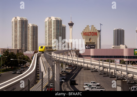 Overlooked by high-rise buildings, a monorail train runs on a track above the streets of Las Vegas, Nevada, USA, Stock Photo