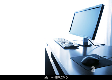 Office life,computer with desk isolated on the white--toned blue. Stock Photo