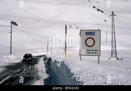 car driving on frozen road to Splugen Pass between Italy and Switzerland Stock Photo