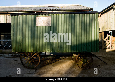 Old agricultural trailer/caravan, parked in the courtyard of a farmyard. Stock Photo