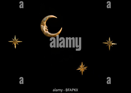 Gold shiny moon and stars sparkly hanging christmas decorations against a black background