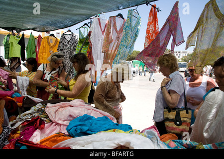 Women buying Indian clothes on open air market stall in Lagos Stock Photo