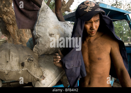 Burmese worker loading coal on a truck at the Mandalay Jetty Stock Photo