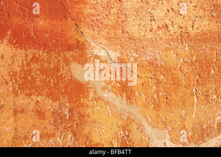 Orange yellow painted plater wall with ageing paint surface, rustic texture Stock Photo