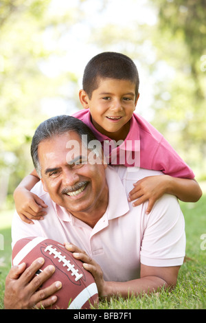Grandfather With Grandson In Park With American Football Stock Photo