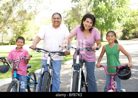 Grandparents In Park With Grandchildren Riding Bikes Stock Photo