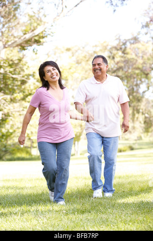 Senior Couple Running In Park Stock Photo