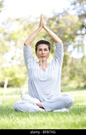 Senior Woman Doing Yoga In Park Stock Photo