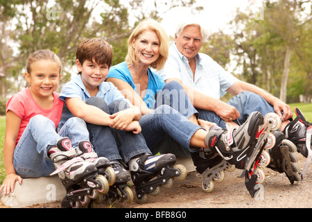 Grandparents And Grandchildren Putting On In Line Skates In Park Stock Photo