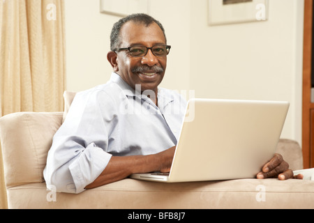 Senior Man Using Laptop At Home Stock Photo