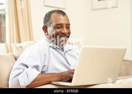 Senior Man Using Laptop At Home Stock Photo