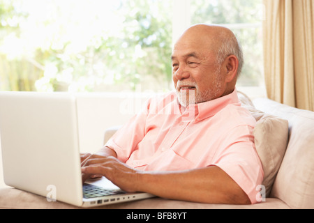 Senior Man Using Laptop At Home Stock Photo