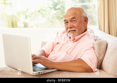 Senior Man Using Laptop At Home Stock Photo