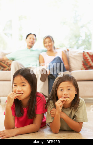 Two Girls Eating Cookies At Home Stock Photo