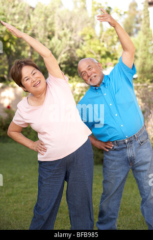 Senior Couple Exercising In Garden Stock Photo