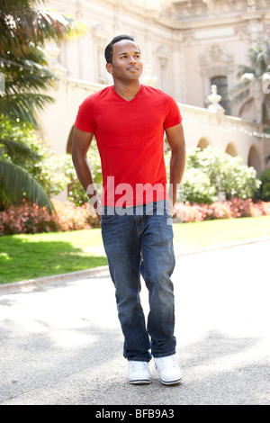Young Man Walking Through City Street Stock Photo
