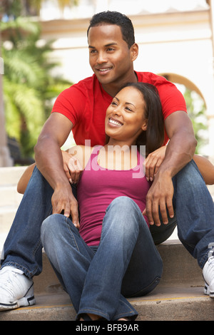 Young Couple Sitting On Steps Of Building Stock Photo