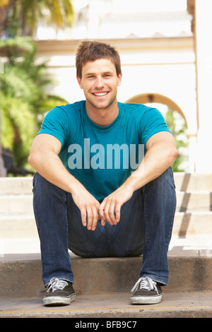 Young Man Sitting On Steps Of Building Stock Photo
