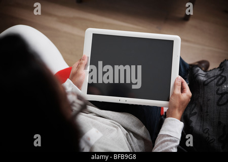 A woman uses a tablet PC in a bright homely environment, Stock Photo