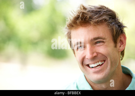 Portrait Of Young Man Sitting In Park Stock Photo