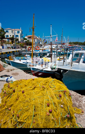 Yellow fishing nets in front of fishing boats at the old harbour at Spetses, Greece Stock Photo