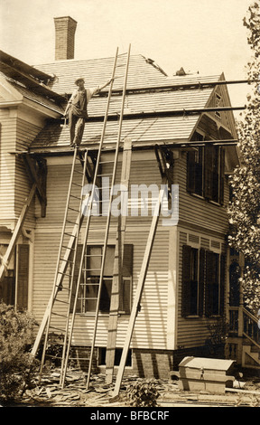 Roofer Repairing Roof on Victorian House Stock Photo