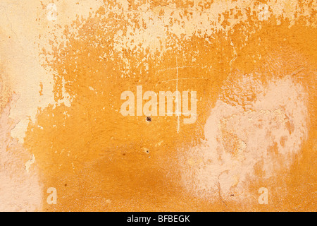 Orange yellow painted plater wall with ageing paint surface, rustic texture Stock Photo