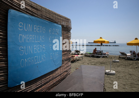 sun loungers and umbrellas price list in euros and cypriot pounds on sandy beach akti olympion Limassol lemesos Stock Photo