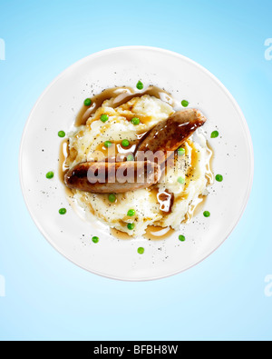 Sausages, mashed potato, peas and gravy to indicate dinner time of nine o'clock. Stock Photo