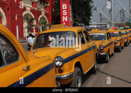 Yellow ambassador taxis queuing outside Howrah Station Kolkata Stock Photo