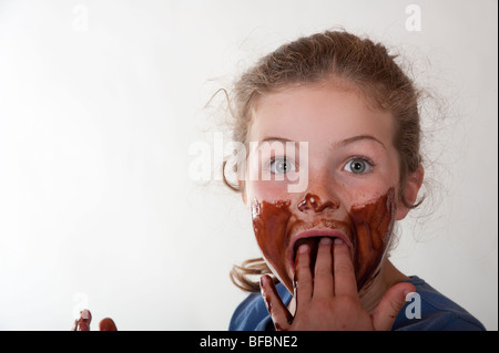 surprised little girl with chocolate covered face Stock Photo