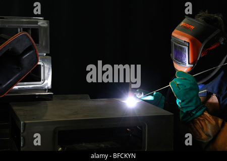 Welder TIG Welding Aluminum Cases at an Engineering Works Stock Photo