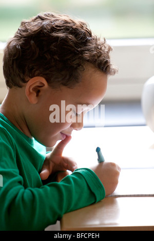 Seven year old boy is writing Stock Photo