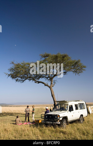 Tourists On Safari having Picnic - Masai Mara National Reserve, Kenya Stock Photo