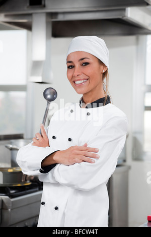 portrait of female chef looking at camera in kitchen Stock Photo