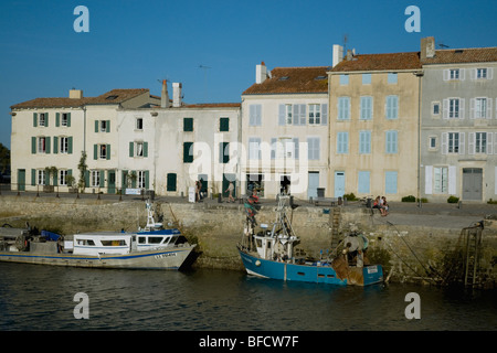 Fishing boats and harbour-side houses in Ile de Ré's popular holiday village of Saint-Martin-de-Ré on France's west coast Stock Photo