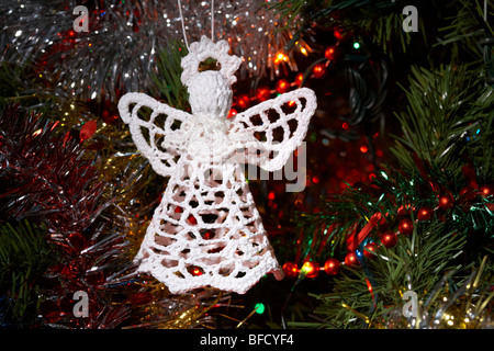 angel decoration hanging on an artificial christmas tree Stock Photo
