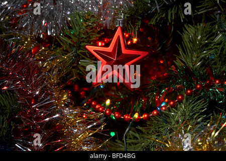 red star decoration hanging on an artificial christmas tree Stock Photo