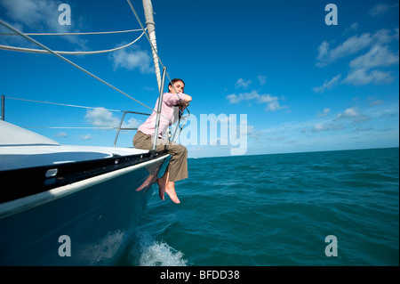 A woman sits on the bow of a boat off of Florida. Stock Photo