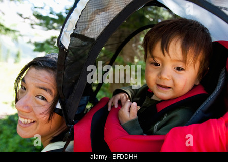 Mother carries her child in backpack. Backpacking trip in the Maroon Bells in Snowmass Wilderness outside of Aspen, Colorado Stock Photo