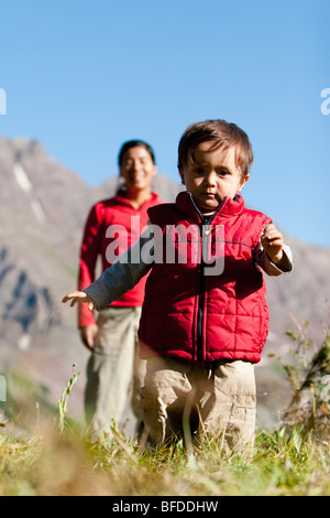 Mother watches 14 month old son explore meadow taking break on backpacking trip. Maroon Bells Snowmass Wilderness Aspen Colorado Stock Photo