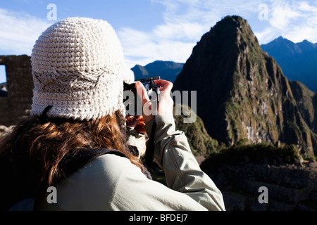 A teenager takes a photo of Machu Picchu, the ancient ruins in the Sacred valley of Peru. Stock Photo
